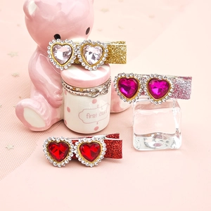 Detail view of heart-shaped gemstone hair clips with glitter duckbill clips for girls