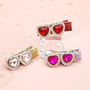 Close-up of glitter hair clips with heart-shaped gemstones and sparkling rhinestones