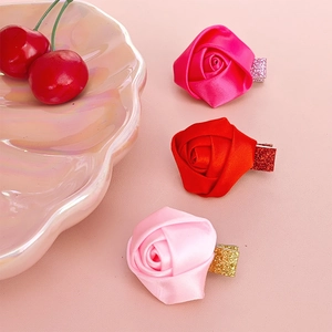 Three-piece rose fabric hair clip set in red and pink satin with glitter accents