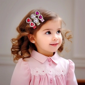 Detailed view of three heart-shaped rhinestone hair clips worn by a young girl