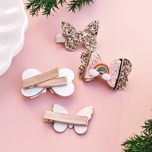 Detail showing glitter butterfly clips and rainbow bow with ribbon-wrapped metal backings