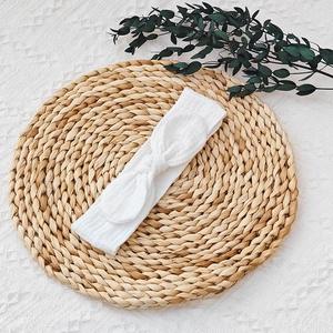 Detailed texture of a soft white cotton baby headband with a cute bunny ear bow.