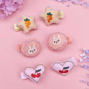 Detailed embroidery of star, rabbit and cherry patterns on colorful fabric hair clips