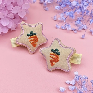 Detailed view of beige star embroidery hair clips with carrot pattern and pink stitched edges