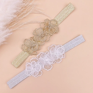 Detailed view of handmade lace flower baby headbands in gold and silver embroidery