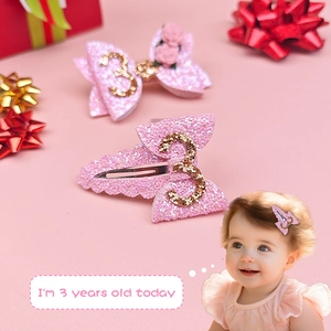 Detail of pink glitter bow hair clips for 3rd birthday with a gold number 3 and small flower