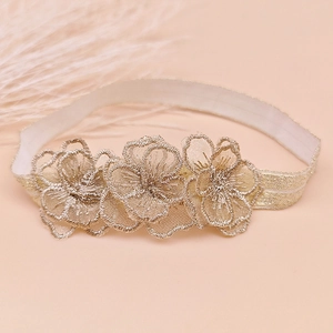 Close-up of baby lace headband with three-dimensional embroidered flowers and soft elastic band
