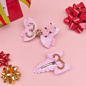 Detail of pink glitter hair bow clips with number 3 and small rose for birthday