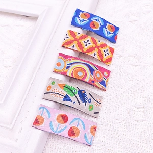Detailed close-up of embroidered floral fabric hair clips with colorful patterns on lace