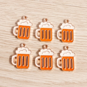 Set of six orange beer mug charms with gold-tone rings for DIY jewelry on wood background