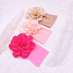 Three soft nylon baby headbands with large fabric flowers in pink and beige colors