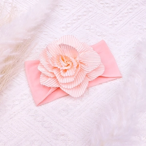 Detailed close-up of soft pink nylon baby headband with a 3D layered fabric flower detail