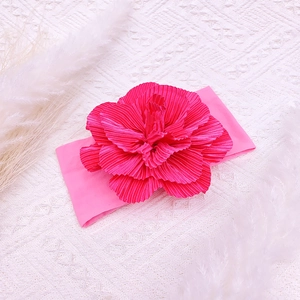 Detail of soft peach nylon baby headband featuring a large pleated handmade flower