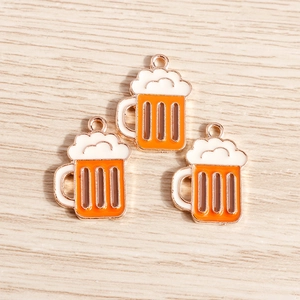 Macro detail of orange enamel beer mug charms with rose gold plating for DIY jewelry