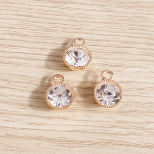 Detailed view of three circular crystal pendants with gold frames and intricate beaded edges