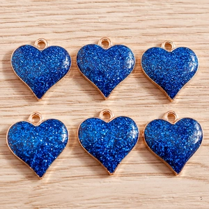Détail de six pendentifs cœur à paillettes bleu foncé avec bords dorés pour bijoux DIY