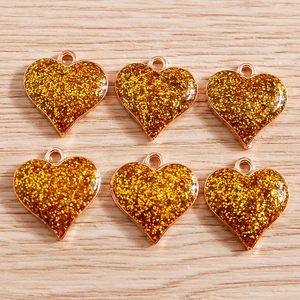 Vue détaillée de six pendentifs cœur dorés avec résine pailletée pour création bijoux