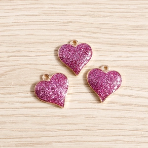 Vue détaillée de pendentifs cœurs rose avec paillettes pour la création de bijoux DIY