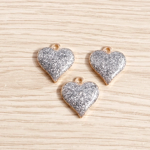 Vue macro de pendentifs en forme de cœur à paillettes argentées pour création de bijoux