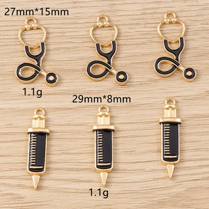 Détails de breloques médicales montrant le stéthoscope et la seringue avec dimensions