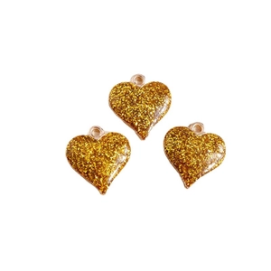 Trois pendentifs cœur dorés avec paillettes et anneaux métalliques pour création de bijoux
