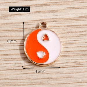 Macro detail of orange and white yin yang heart pendant with measurements on wood