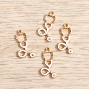 Vue macro de quatre pendentifs stéthoscope en émail blanc avec cadre en métal doré
