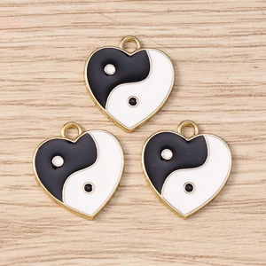Detailed view of heart-shaped Yin Yang enamel charms for DIY jewelry making