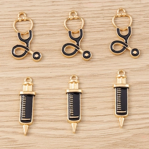 Détails macro de pendentifs stéthoscope et seringue en émail noir sur fond en bois clair