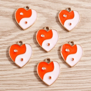 Detailed view of heart-shaped Yin Yang enamel pendants with golden frames for jewelry DIY