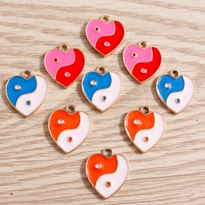 Macro detail of heart-shaped Yin Yang enamel charms in various vibrant color combinations