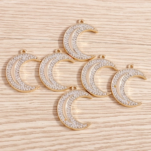 Five gold moon charms with sparkling white crystals for DIY jewelry making and crafts