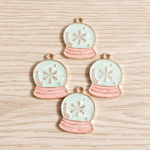 Detailed view of four snowflake crystal ball alloy charms with light green oil drip finish