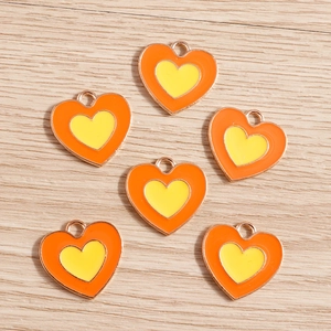 Dettaglio di sei ciondoli a cuore in lega con smalto arancione e giallo e finitura oro rosa