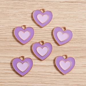 Dettaglio di ciondoli a cuore in lega con smalto viola e finitura placcata oro rosa