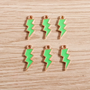 Detail of six lightning bolt pendants with green enamel and gold-plated metal frames