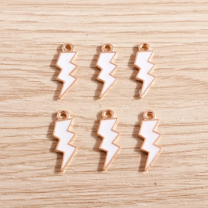 Detail showing 6-piece set of lightning bolt alloy charms with white enamel and gold trim