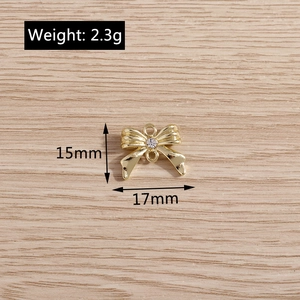 Vue détaillée du pendentif nœud doré serti de strass avec structure à double anneau