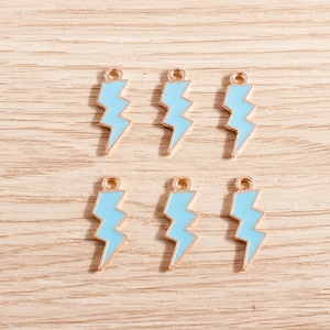 Detail of six lightning charms in rose gold alloy with light blue enamel for DIY jewelry