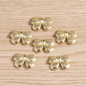 Golden bow pendant with white pearl for DIY jewelry making 6pcs pack on wood background