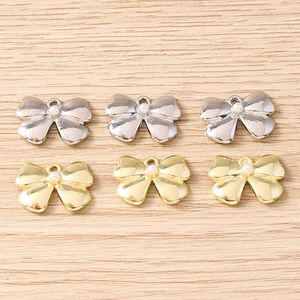 Detailed view of gold and silver bow pendants with pearls for jewelry making