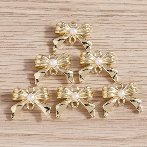 Vue détaillée de pendentifs nœuds dorés avec perles pour création de bijoux