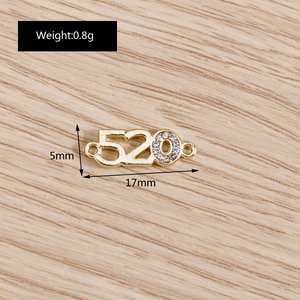 Vue macro du pendentif 520 doré avec strass sur fond de bois naturel, 17mm x 5mm