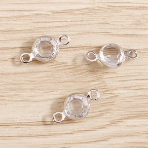 Macro detail of transparent crystal link connectors with silver metal frame for DIY jewelry