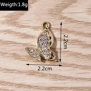 Macro detail of butterfly pendant with white rhinestones and dimensions showing 2.2cm size