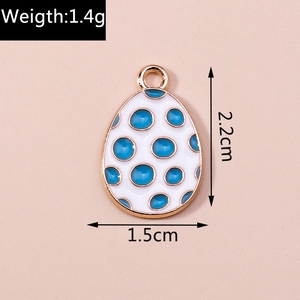 Detailed view of white enamel egg pendant with blue polka dots and golden alloy plating