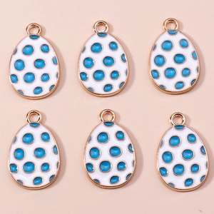 Detail view of white enamel egg pendants with blue polka dots and golden metal loops