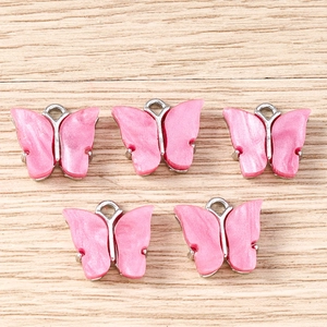 Detail of pink acrylic butterfly pendants with silver metal edges for DIY jewelry making