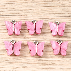 Detail of six pink butterfly charms with silver metal edges for DIY jewelry making