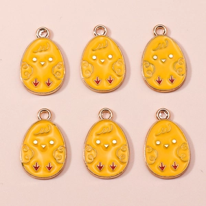 Detail view of six yellow enamel cartoon chick pendants with rose gold metal edges for DIY